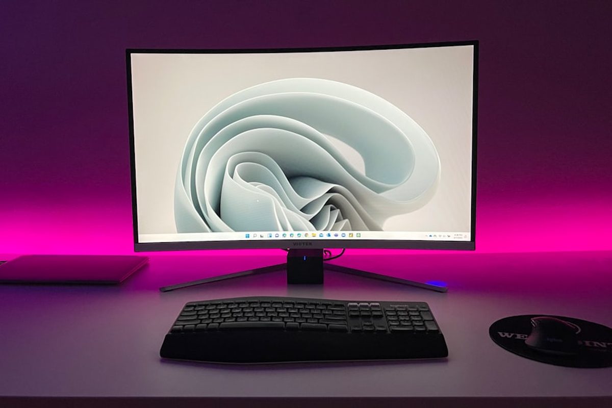 Širokoúhlý monitor na pracovním stole ve tmě